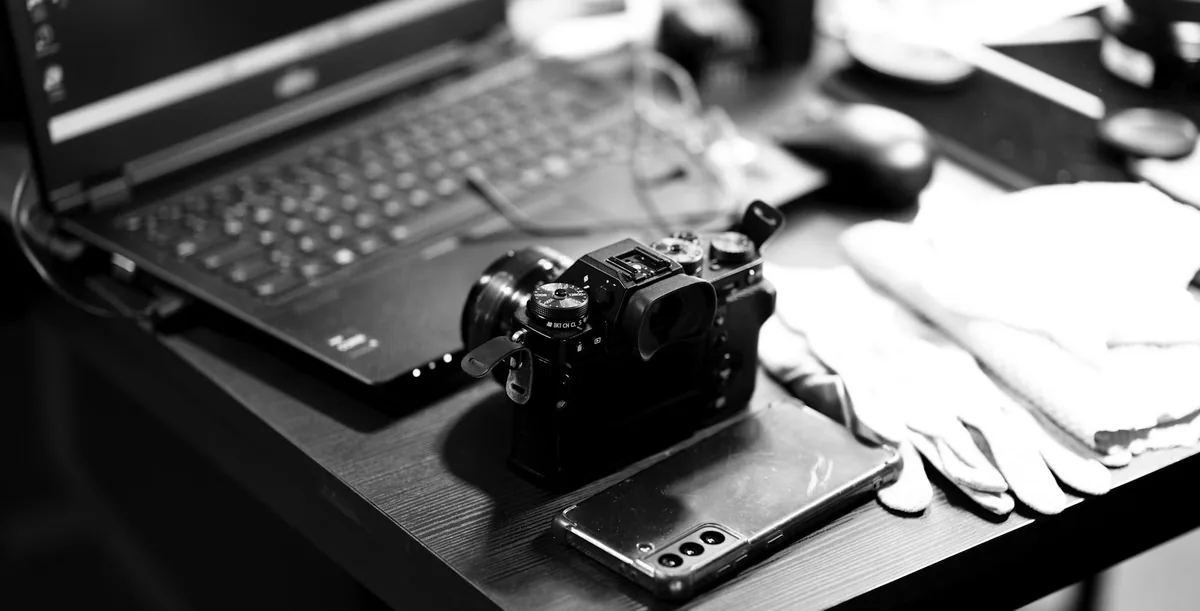 Camera, smartphone, and laptop together on a working desk