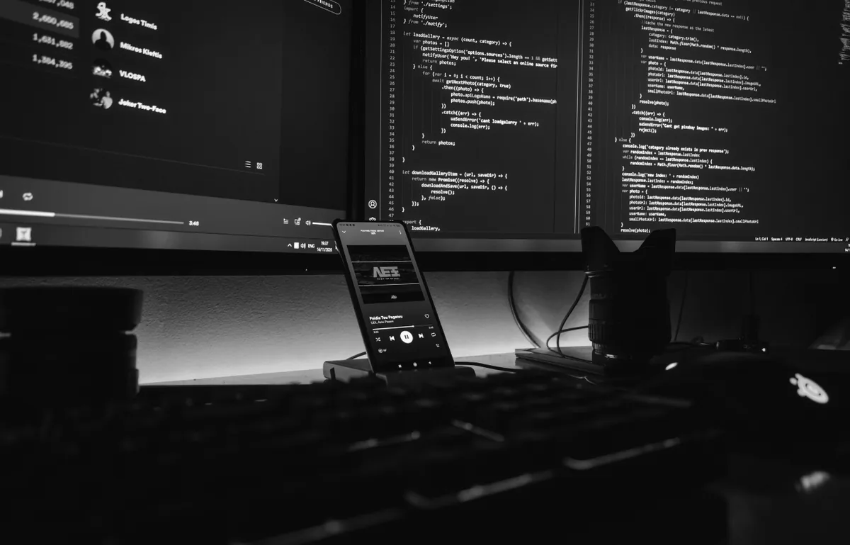 A dark workstation with code on the monitor and a keyboard