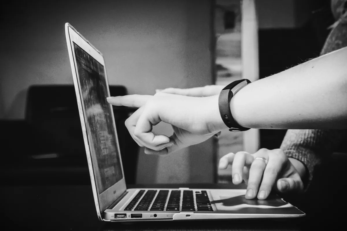 Hands reviewing a website together on a laptop